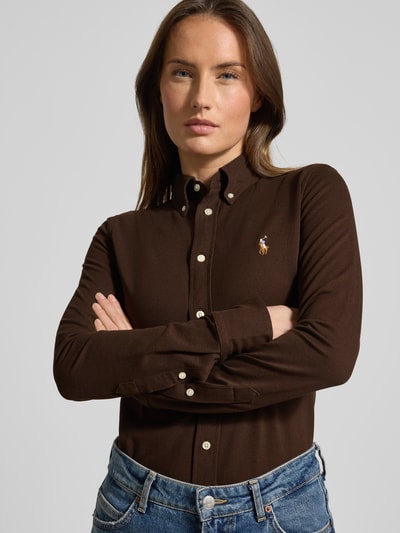 Kobiece modelka nosi bluzkę koszulową z wyhaftowanym logo, Polo Ralph Lauren, brąz, bawełna, krój slim fit, kołnierzyk typu button down, listwa guzikowa, długość tyłu 67 cm, długość rękawa 64 cm, ujęcie: z przodu, zbliżenie na górną część ciała.