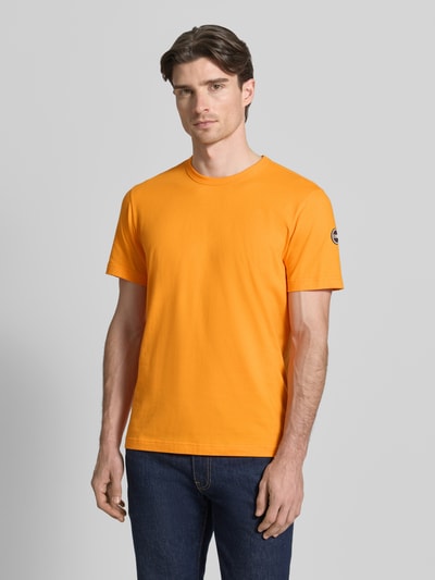 Männermodel trägt Regular Fit T-Shirt aus Baumwolle von Colmar Originals in Orange mit Rundhalsausschnitt, Ganzkörperansicht von vorne.