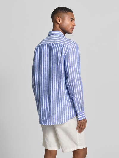 Męski model nosi Slim Fit Freizeithemd aus reinen Leinen od Christian Berg Men, w niebiesko-białe paski, kołnierzyk typu button down, krój slim fit, długi rękaw, sportowe mankiety, długość tyłu 79 cm, szerokość ramion 48 cm, długość rękawów 65 cm, koszula casualowa z lnu, widok całej sylwetki z tyłu.