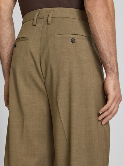 Männermodel trägt Wide Fit Stoffhose aus wolmix von Filippa K in beige met Achterzakken, knoop- en ritssluiting, detailaufnahme Rückansicht.