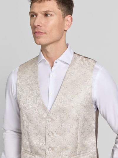 Männermodel trägt Weste mit V-Ausschnitt und Leistentaschen von Wilvorst in Beige mit dezentem Muster, gerader Schnitt, Nahaufnahme Oberkörper.