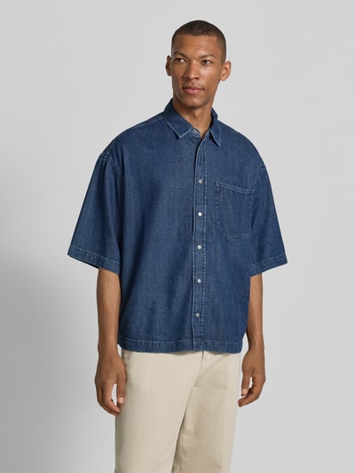 Męski model nosi Oversized Jeanshemd aus Baumwoll-Lyocell-Mix von Armedangels, denim, krój oversize, kieszeń na piersi, przód, ujęcie całej sylwetki