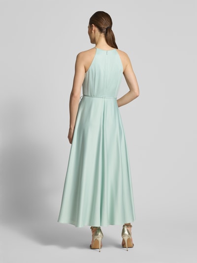Frauenmodel trägt Cocktailkleid aus Satin mit Bindegürtel von Jake*s Cocktail, hellgrün, A-Linie, Neckholder, Ganzkörperansicht Rückansicht