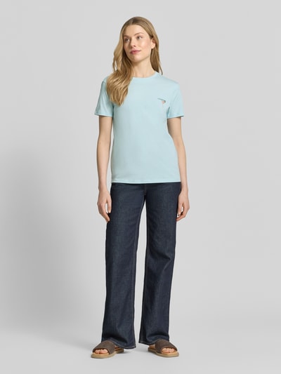 Kobiece model prezentuje damski t-shirt z bawełny o kroju regular fit, wyhaftowany motyw, okrągły dekolt, Jake*s Casual, długość tyłu 61 cm w rozmiarze S, T-Shirt mit Motiv-Stitching von Jake*s Casual, całkowity widok z przodu.