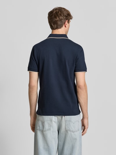 Männermodel trägt dunkelblaues Regular Fit Poloshirt mit Logo-Stitching Modell 'Hedin' von Blend, reine Baumwolle, Rückansicht Ganzkörperansicht.