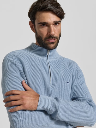 Mężczyzna nosi Regular Fit Strickpullover aus reiner Baumwolle mit Troyer-Kragen od Fynch-Hatton, jasnoniebieski, żakardowy wzór, długie rękawy, ściągacze, logo wyszywane, krój regular fit, czysta bawełna, perspektywa z przodu, zbliżenie na górną część ciała.