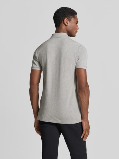 Männermodel trägt Slim Fit Poloshirt aus reiner Baumwolle von Polo Ralph Lauren in hellgrau, glatte Textur, Ganzkörperansicht Rückansicht.