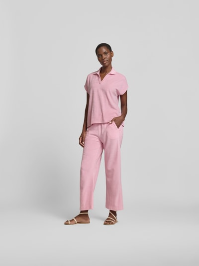 Frauenmodel trägt Poloshirt in Frottee-Optik von Juvia in Rosa, Baumwoll-Mix, Relaxed-Fit, Polokragen, Kurzärmelig, Ganzkörperansicht von vorne.