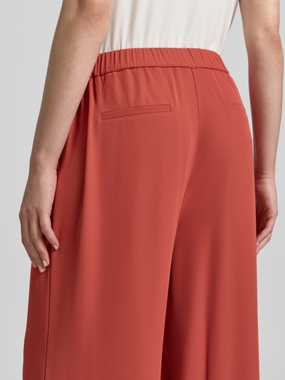 Frauenmodel trägt Hose mit elastischem Bund von Jake*s Collection in Rot, Material-Mix mit Stretch-Anteil, Gesäßtaschen, Detailaufnahme Rückansicht.