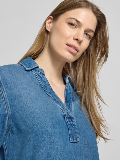 Frauenmodel trägt Relaxed Fit Jeanskleid aus Lyocell-Baumwoll-Mix von Marc O'Polo, Denim-Optik, V-Ausschnitt, Nahaufnahme Oberkörper.
