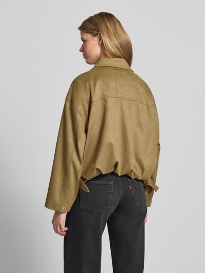 Frauenmodel trägt Jacke in Leder-Optik mit Reißverschluss und Eingrifftaschen von Gina Tricot in Khaki, Material-Mix, Relaxed Fit, Ganzkörperansicht Rückansicht.