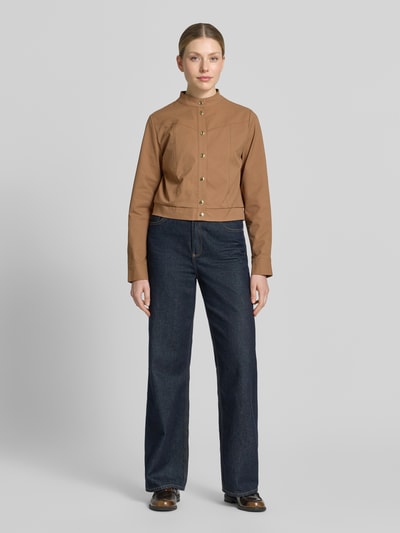 Frauenmodel trägt Jacke mit Stehkragen und Knopfleiste von monari in Braun, Regular-Fit, Teilungsnähte, Jeans, Ganzkörperansicht von vorne, Rückenlänge 46 cm, Schulterbreite 36 cm, Brustweite 48 cm, Ärmellänge 63 cm, Größe 36.