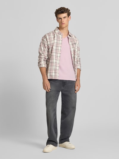 Männermodel trägt T-Shirt aus Baumwoll-Leinen-Mix mit V-Ausschnitt von Superdry, Regular-Fit, dezentes Stitching, Rückenlänge 68 cm, Ganzkörperansicht von vorne.