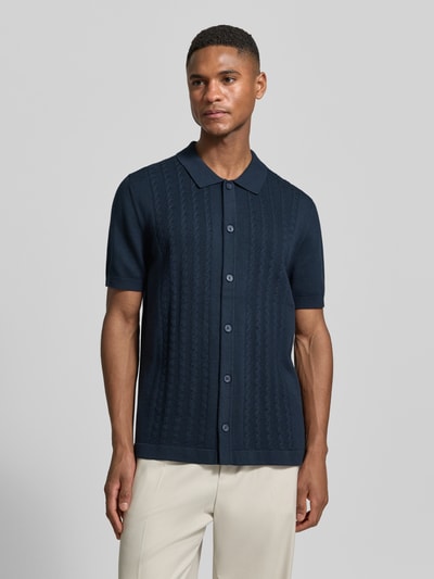 Männermodel trägt dunkelblaues Slim Fit Poloshirt mit 1/2-Arm von OLYMP Level Five, Zopfmuster, Knopfleiste, Baumwoll-Mix, Ganzkörperansicht von vorne.