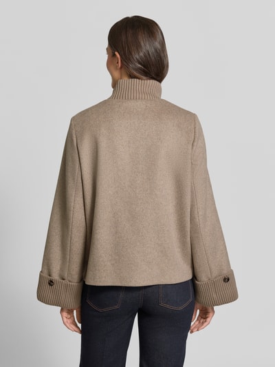 Vrouwenmodel draagt Jacke aus Woll-Mix met gestricktem Stehkragen van comma in beige, zichtbare structuur, loose fit, wollen look, Ganzkörperansicht Rückansicht. Ruglengte maat 36: 62 cm, schouderbreedte: 36 cm, borstwijdte: 53 cm, mouwlengte: 64 cm, met viscose, zij-steekzakken, drukknoop- en ritssluiting, gebreide opstaande kraag en mouwboorden.