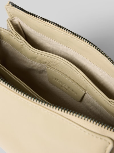 Produktfoto, detailreiche Nahaufnahme der Crossbody Bag mit Logo-Prägung Modell 'Nina' von LIEBESKIND BERLIN, beige Leder, geteiltes Hauptfach, sichtbarer Reißverschluss, neutrale Textur, abgesetztes Innenfutter