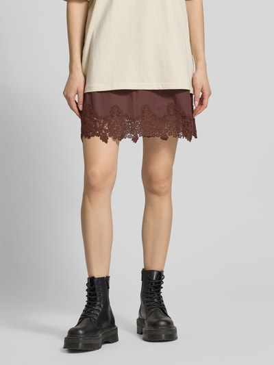 Frauenmodel trägt Minirock mit Spitze Modell 'LANI' von Topshop in Braun, Reine Baumwolle, A-Linie, elastischer Bund, Nahaufnahme Unterkörper.