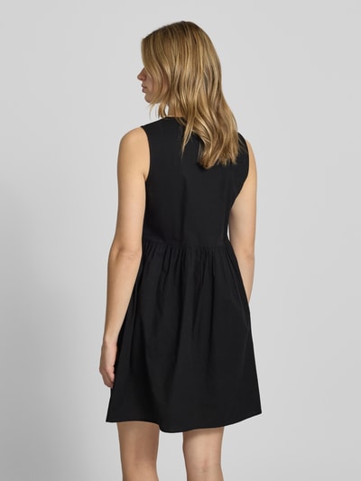 Frauenmodel trägt Ausgestelltes Blusenkleid aus reiner Baumwolle Modell 'JOLLY' von Pieces, Optik: Unifarben, Passform: Ausgestellt, Mini-Länge, Rundhals, Verschluss: Bindebänder, Ärmelform: Ohne Ärmel, Material: Reine Baumwolle, Ganzkörperansicht Rückansicht.