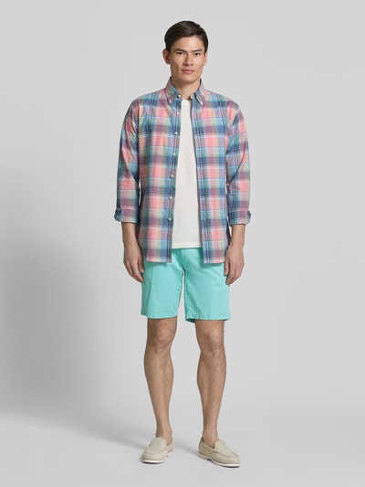 Męski model nosi Relaxed Fit Bermuda aus Baumwoll-Mix od Brax, jasnoturkusowy, unikatowy, bawełniany materiał, pasek, kieszenie boczne, guzik, rozporek, Ganzkörperansicht von vorne.