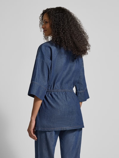 Kobiece model prezentuje bluzka jeansowa z mieszanki bawełny i lnu, taliowany fason, stójka, wiązanie, rękaw o dł. 1/2 od Jake*s Collection, długość tyłu 76 cm, długość rękawów 30 cm, widok całej sylwetki od tyłu.