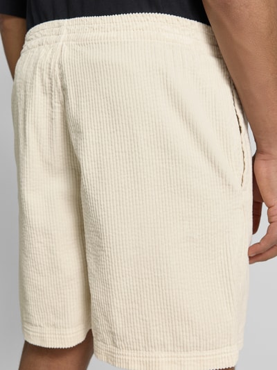 Männermodel trägt Shorts mit elastischem Bund Modell 'PADOW' von American Vintage in Beige, reine Baumwolle, Strukturmuster, Nahaufnahme Rückansicht.