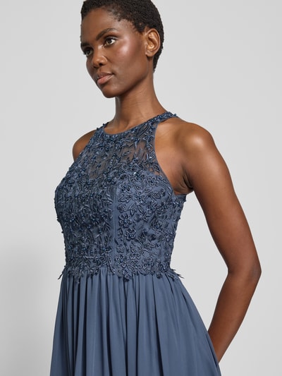 Frauenmodel trägt Abendkleid mit floralen Stickereien von LAONA in Dunkelblau, leichtes Material, taillierter, ärmelloser Schnitt, Nahaufnahme Oberkörper.