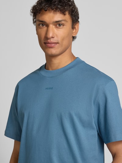 Männermodel trägt Relaxed Fit T-Shirt aus reiner Baumwolle Modell 'DAPOLINO' von HUGO, Optik: Unifarben, Label-Print, Nahaufnahme Oberkörper.