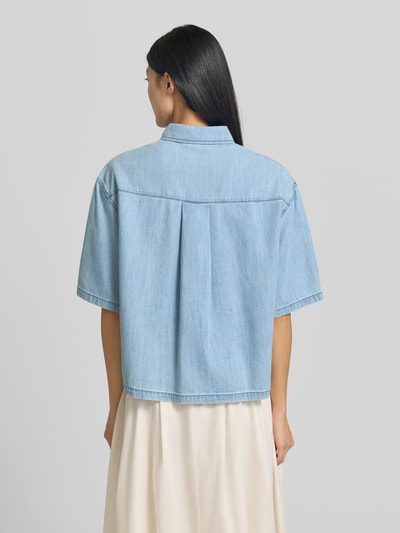 Frauenmodel trägt Relaxed Fit Kurzarmbluse aus reiner Baumwolle von s.Oliver RED LABEL in hellem Blau, glatte Textur, Ganzkörperansicht Rückansicht.