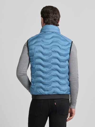 Männermodel trägt Regular Fit Steppweste mit Kapuze im Kragen von Tom Tailor in Unifarben, sichtbare Steppstruktur, Ganzkörperansicht Rückansicht.