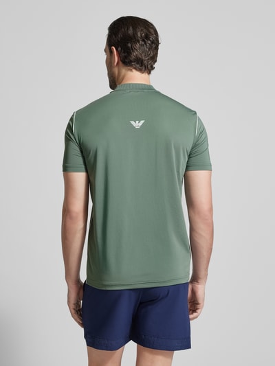 Männermodel trägt Regular Fit T-Shirt mit Stehkragen von EA7 Emporio Armani, grünes Herren T-Shirt, Label-Print, Rückenlänge 70 cm, Ganzkörperansicht Rückansicht.