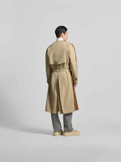 Männermodel trägt Mantel aus reiner Schurwolle von MM6 Maison Margiela in Beige mit Taillengürtel, Rückansicht, Ganzkörperansicht.