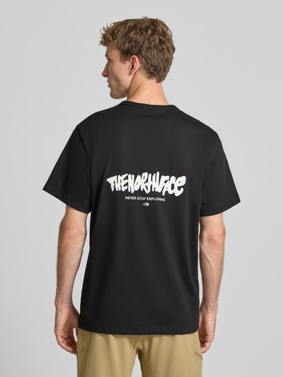 Männermodel trägt Relaxed Fit T-Shirt aus reiner Baumwolle mit Logo-Print von The North Face in Schwarz mit weißem Schriftzug, Rückenlänge 72 cm, Ganzkörperansicht Rückansicht.