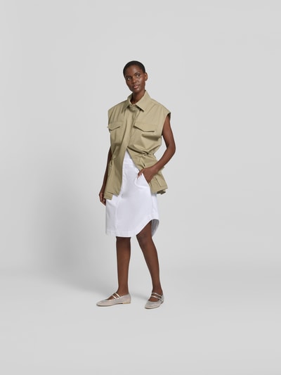 Frauenmodel trägt Knielanger Rock mit Bundfalten von Victoria Beckham aus Reine Baumwolle, A-Linie, Weiß, Knielänge, Ganzkörperansicht von vorne.