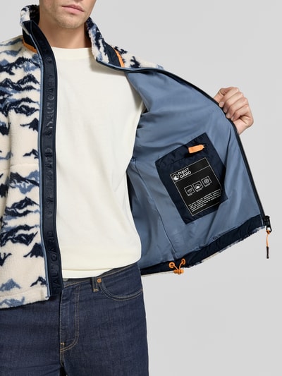 Männermodel trägt Regular Fit Fleecejacke mit opstaande kraag van NAUTGÅRD, blauw-witte print, gestikt logo, Napoleonzak, fleece, Ganzkörperansicht von vorne, context: Heren fleecejack, Ruglengte bij maat M: 70 cm, schouderbreedte: 51 cm, borstwijdte: 59 cm, mouwlengte: 65 cm.