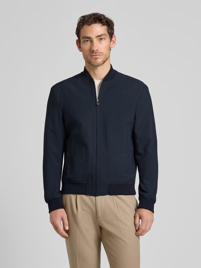 Męski model nosi Bomberjacke mit Eingrifftaschen Modell 'Indro' od JOOP! Collection, prosty krój, granatowy, zdjęcie całej sylwetki z przodu.