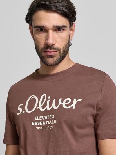 Mężczyzna nosi Regular Fit T-Shirt aus reiner Baumwolle von s.Oliver RED LABEL, kolor jednolity, nadruk z logo, okrągły dekolt, jersey z bawełny, krótki rękaw, materiał gładki, unisex, nahaufnahme górnej części ciała.