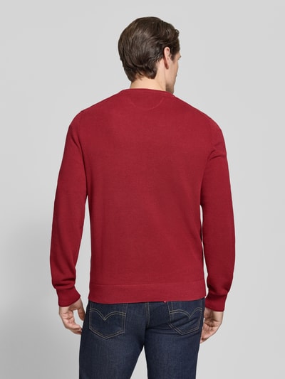 Männermodel trägt Regular Fit Strickpullover aus reiner Baumwolle mit Label-Detail von LERROS, rote Farbe, Strukturstrick, Ganzkörperansicht Rückansicht. Rückenlänge bei Größe M 68 cm, Ärmellänge 69 cm, elastische Abschlüsse.