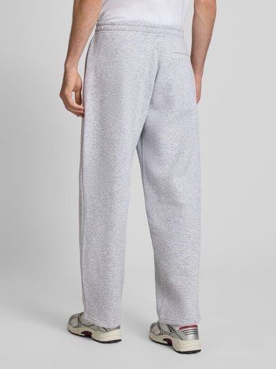 Männermodel trägt Straight Fit Sweatpants mit Logo-Detail von REVIEW, hellgrauer Baumwoll-Mix, elastischer Bund, Ganzkörperansicht Rückansicht.