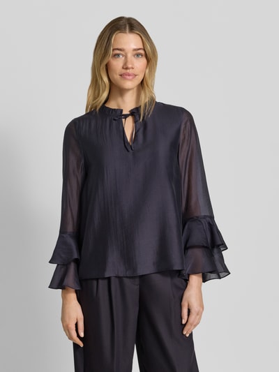 Frauenmodel trägt Regular Fit Bluse aus Lyocell-Mix mit Volants von Comma, dunkelblau mit Schlüsselloch-Ausschnitt, Ganzkörperansicht von vorne. Rückenlänge bei Größe 36: 58 cm, Ärmellänge: 60 cm.
