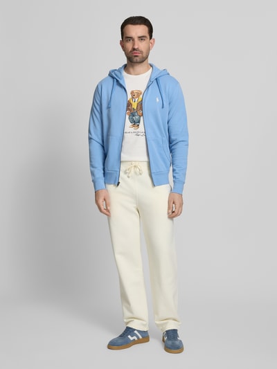 Männermodel trägt Regular Fit Sweatjacke aus reiner Baumwolle von Polo Ralph Lauren in Optik: Unifarben, mit Kapuze, Reißverschluss und Logo-Detail, Langarm, seitliche Eingrifftaschen, Sweat, Ganzkörperansicht von vorne.