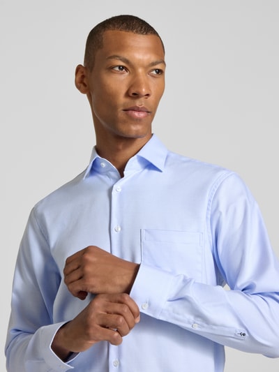 Männermodel trägt hellblaues Regular Fit Businesshemd aus reiner Baumwolle Modell 'New Kent Patch' von Seidensticker, Nahaufnahme Oberkörper, Herren Businesshemd von Seidensticker.