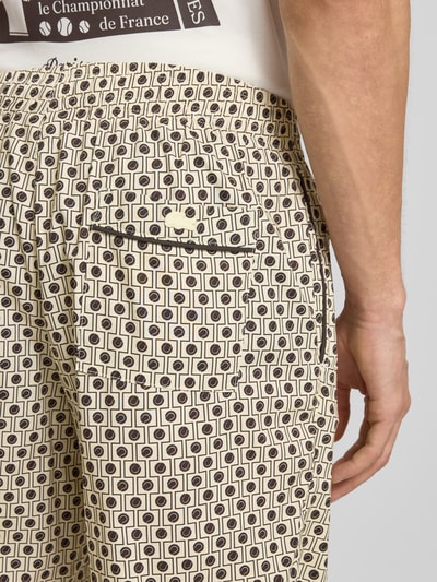 Männermodel trägt Relaxed Fit Bermudas aus Baumwoll-Viskose-Mix von Lacoste mit Optik: Allover-Muster, Logo-Stitching, Twill, Detailaufnahme Rückansicht.