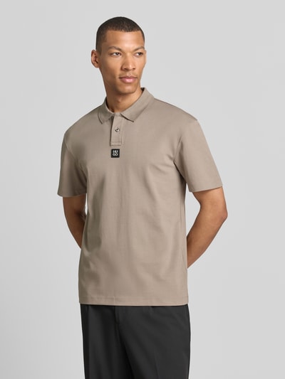 Männermodel trägt Regular Fit Poloshirt aus reiner Baumwolle Modell 'DEABONO' von HUGO, Optik: Unifarben, Ganzkörperansicht von vorne.