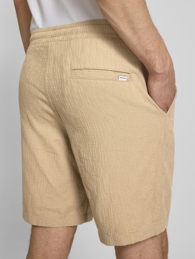 Männermodel trägt Shorts mit Strukturmuster Modell 'JAIDEN' von Jack & Jones, Material-Mix mit Baumwoll-Anteil, Regular-Fit, Beige, Nahaufnahme Rückansicht.