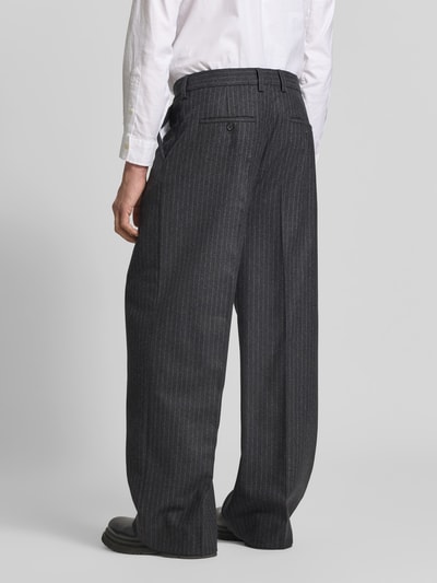 Männermodel trägt Relaxed Fit Stoffhose aus Baumwoll-Mix von Filippa K, grau mit feinem Streifenmuster, Ganzkörperansicht Rückansicht, długość nogawki wewnętrznej w rozmiarze 50: 80 cm, szerokość w rozmiarze 50: 45 cm, bawełniany materiał z kieszeniami z przodu i z tyłu, zapinana na guzik i suwak