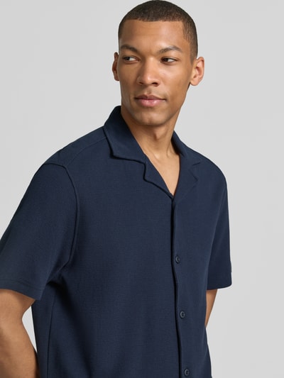 Männermodel trägt Modern Fit Freizeithemd mit Reverskragen von Christian Berg Men in Dunkelblau aus Bio-Baumwolle, Nahaufnahme Oberkörper.