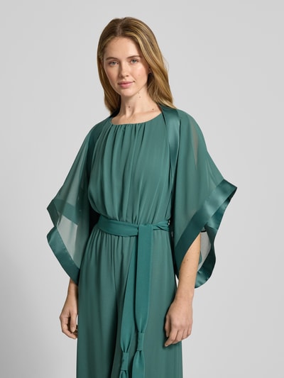 Frauenmodel trägt Bolero mit weitem Arm von Vera Mont in semitransparenter Optik, looser Schnitt, grün, 1/2-Arm, Ganzkörperansicht von vorne. Rückenlänge 32 cm bei Größe S.