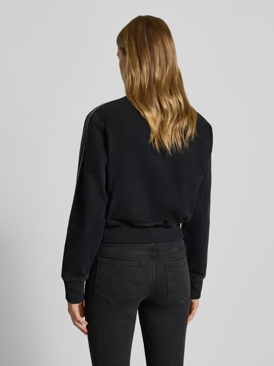 Frauenmodel trägt Jacke mit Reißverschluss von adidas Originals in Schwarz, Regular-Fit, Cropped, Gerippte-Abschlüsse, Stehkragen, Label-Stitching, Eingrifftaschen, Rückenlänge 51 cm, Schulterbreite 45 cm, Brustweite 41 cm, Ärmellänge 62 cm, Ganzkörperansicht Rückansicht.