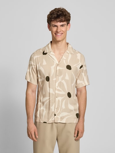 Männermodel trägt Regular Fit Freizeithemd aus reiner Viskose Modell 'DASH' von Only & Sons, kwiatowy wzór na całej powierzchni, beż i zieleń, splot twill, krótki rękaw, kołnierzyk koszulowy, listwa guzikowa na całej długości, pas na plecach, Ganzkörperansicht von vorne.