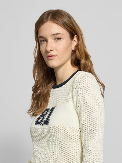 Frauenmodel trägt Slim Fit Pullover in Strick-Optik von Guess Jeans, cremefarben, semitransparent, Baumwoll-Mix, Nahaufnahme Oberkörper.